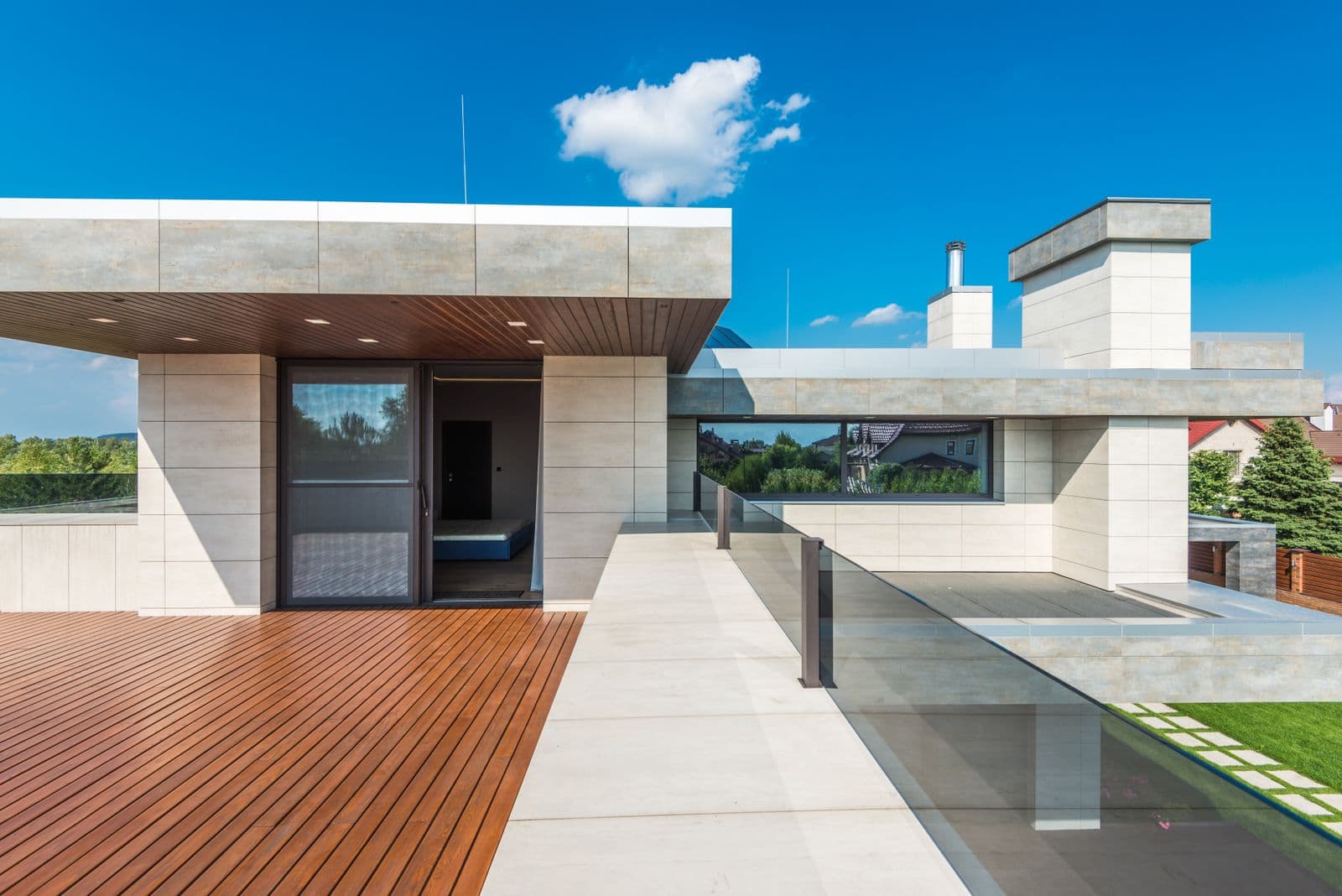 Modern dakterras met houten vlonder en glazen balustrade